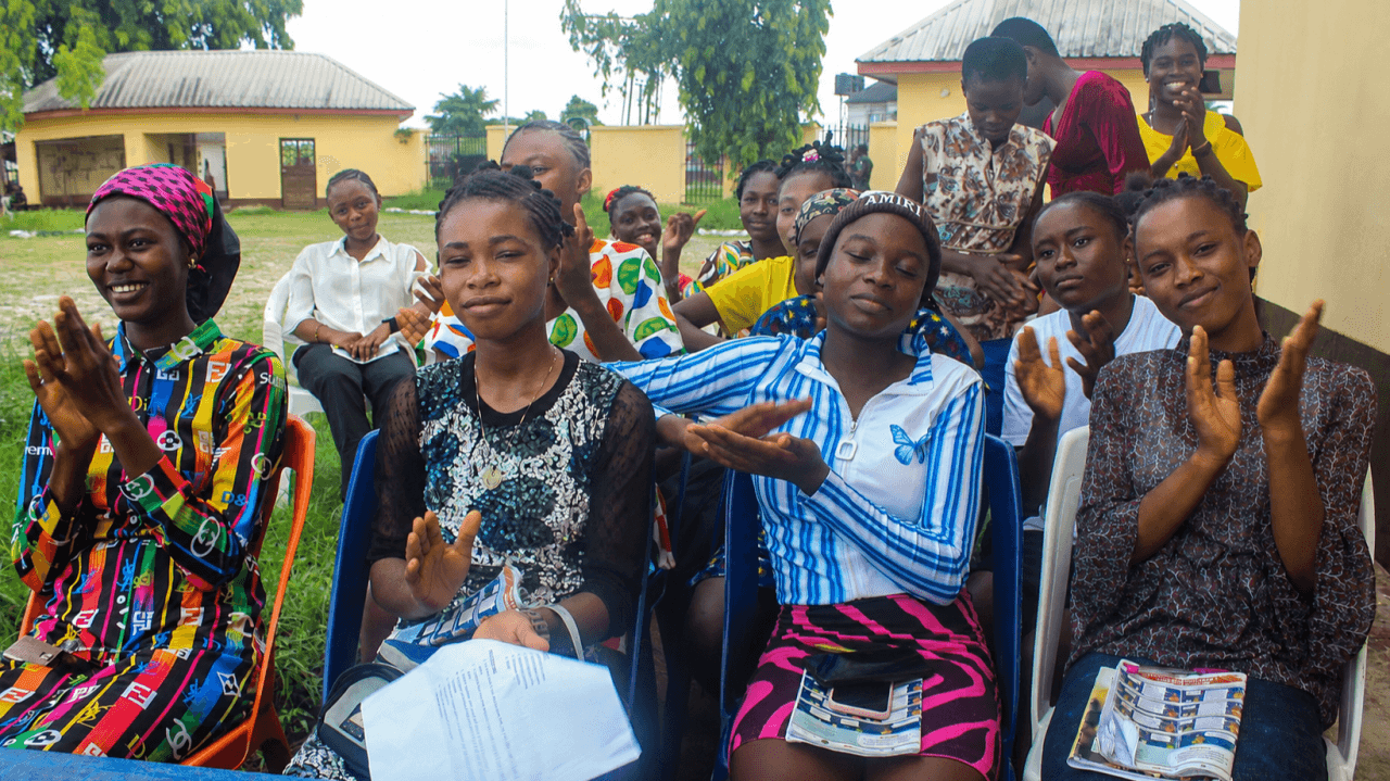 Adolescent girls clapping and smiling at an A360-HEEP safe-space session in Rivers State